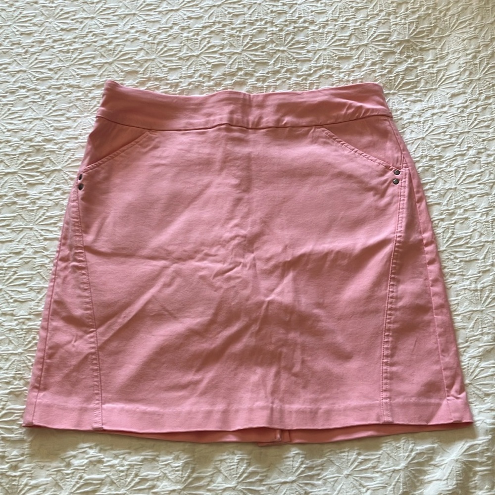Light pink stretchy skort with attached pink short, front pockets.